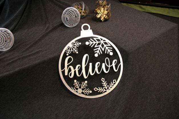 Ornament made of high-quality wood and features a unique, laser-cut design of the word "believe" surrounded by snowflakes