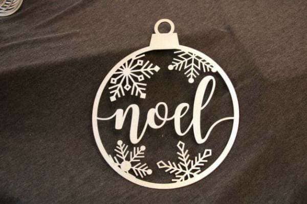 Ornament made of high quality wood and features a unique laser cut design of the word noel surrounded by snowflakes dragonfly wood arts