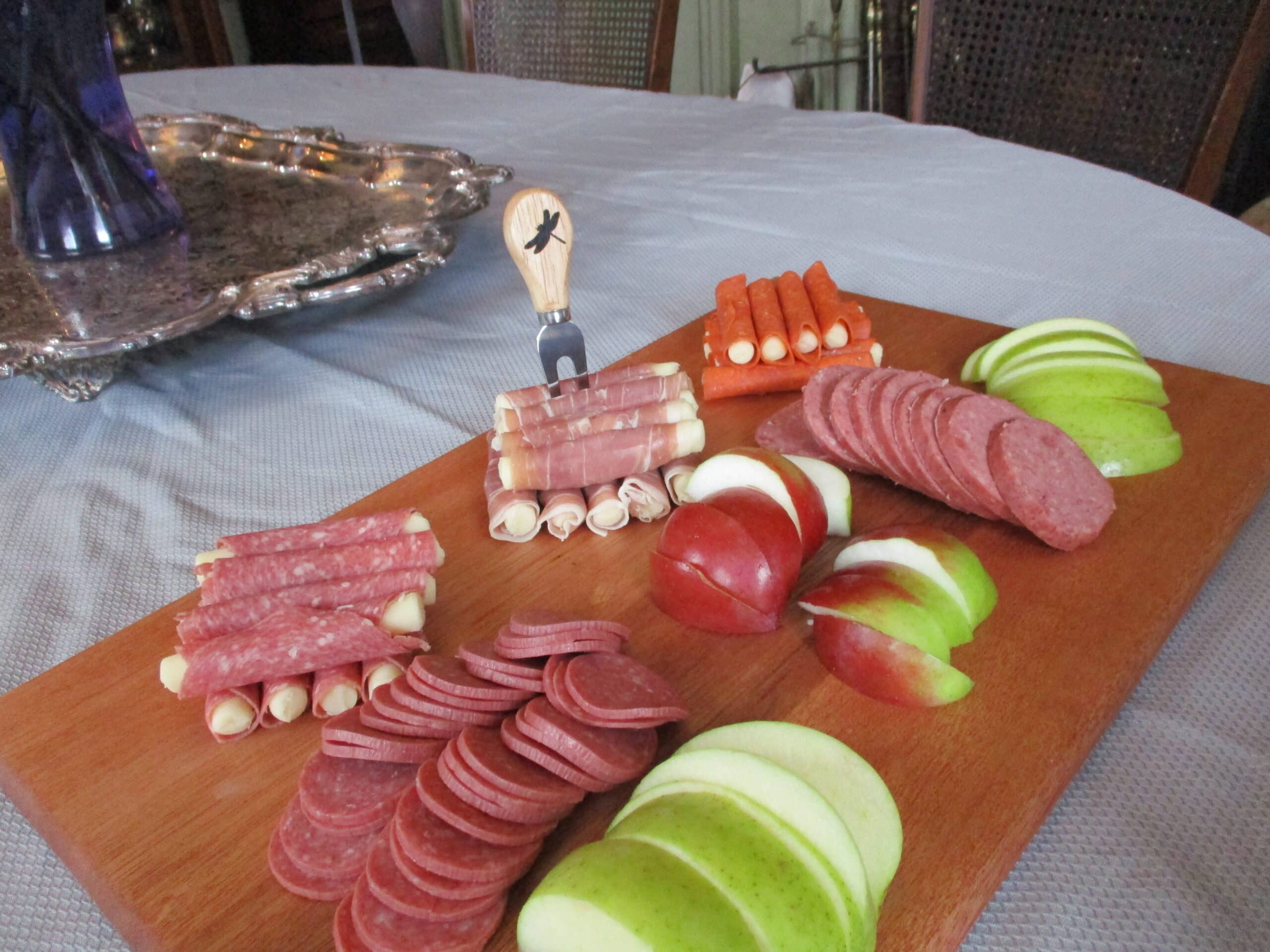 Custom Mahogany cutting board/charcuterie board as a housewarming gift pictured with fruit, cheese, and cured meats.