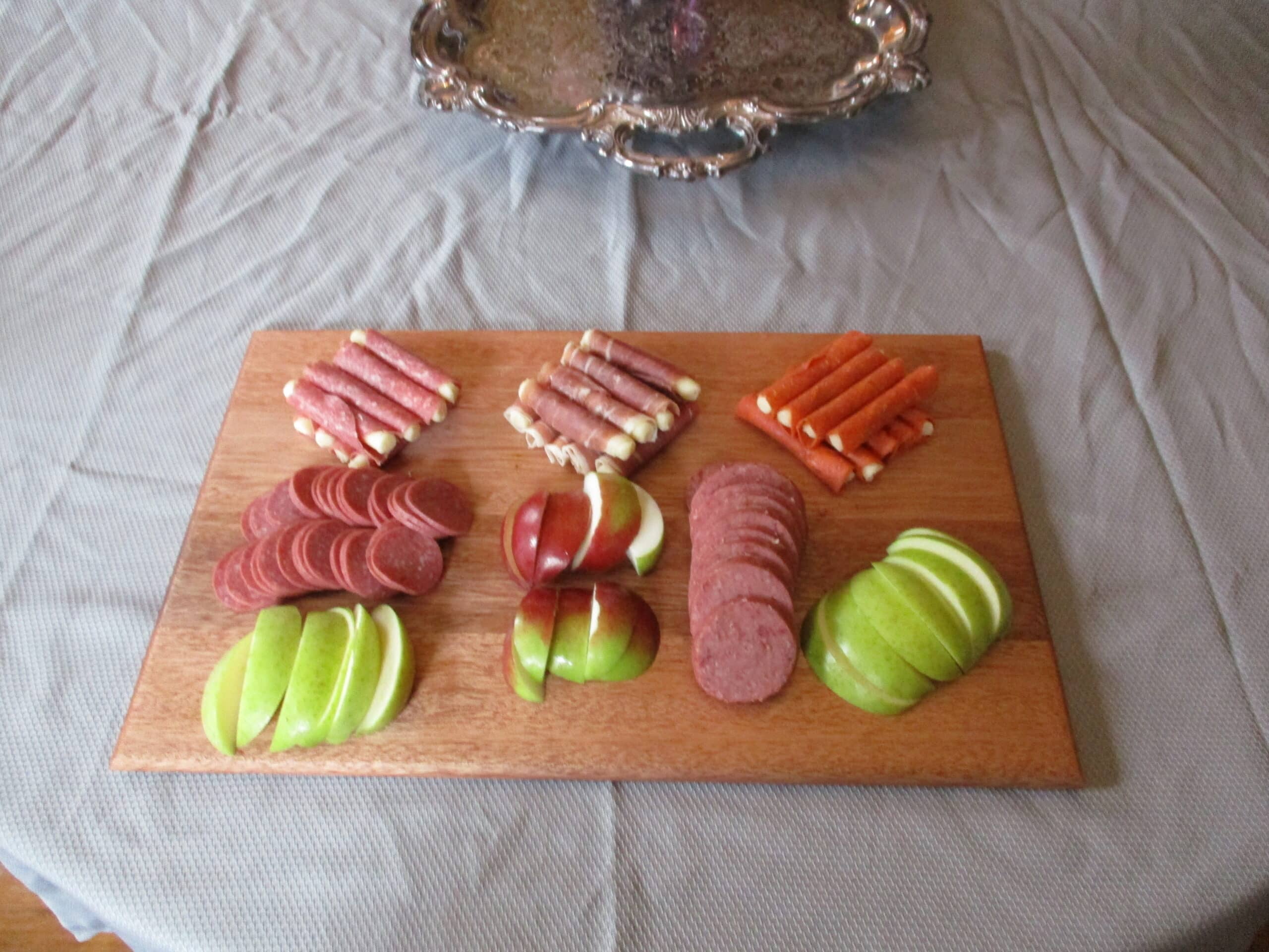 Custom Mahogany cutting board/charcuterie board as a housewarming gift pictured with fruit and cured meats.