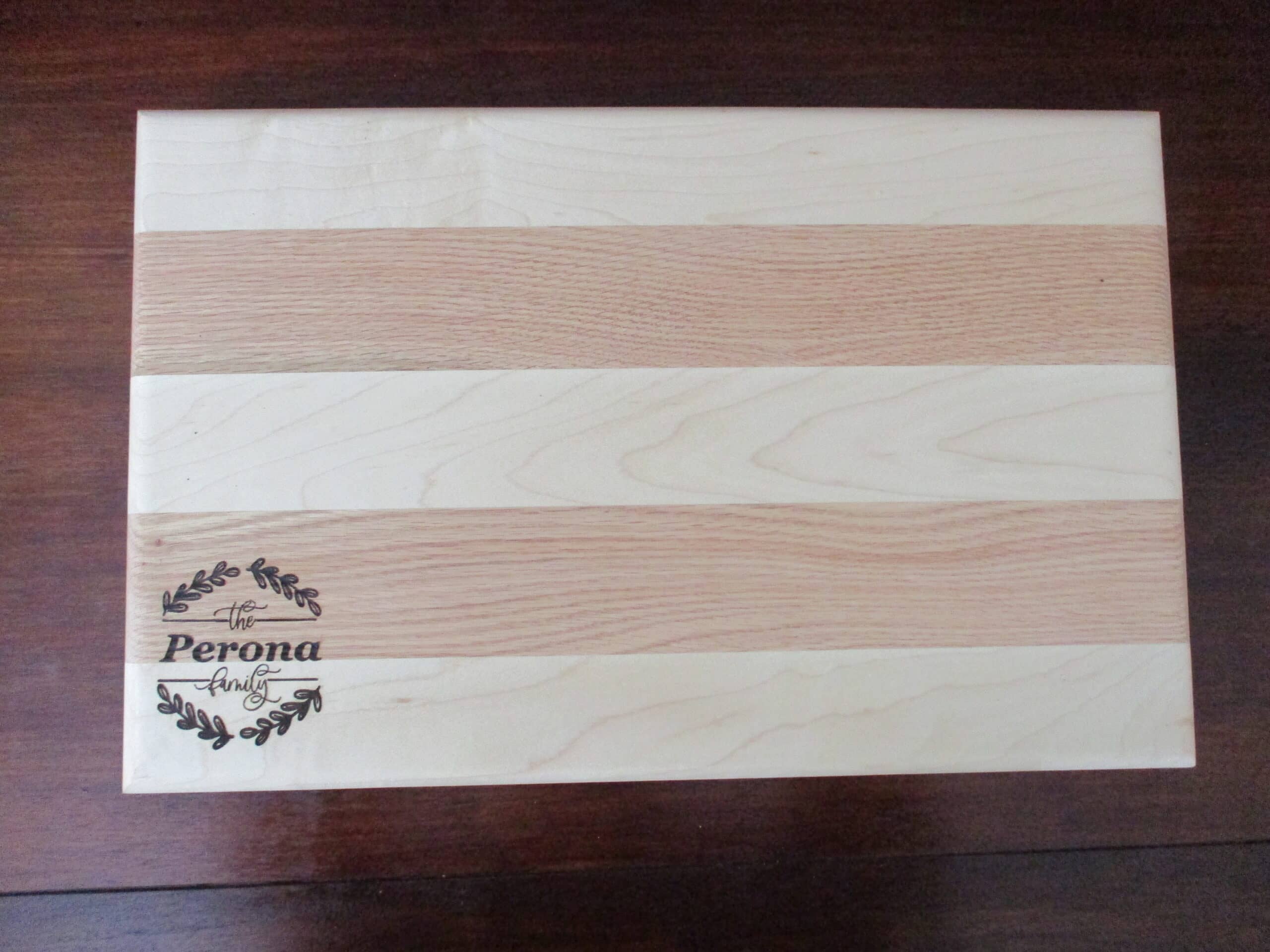 Custom family wreath engraved on Maple and Cherry cutting board/charcuterie board as a corporate gift.