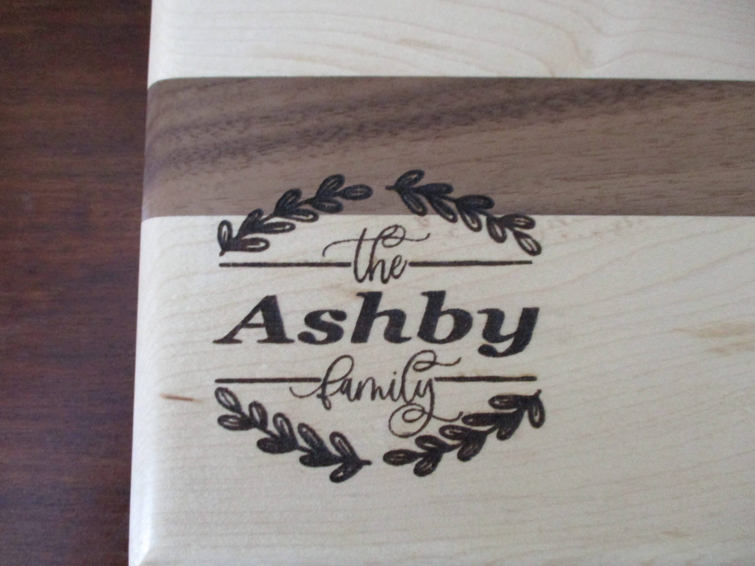 Custom wreath engraved on Maple and Walnut cutting board/charcuterie board as a corporate gift.