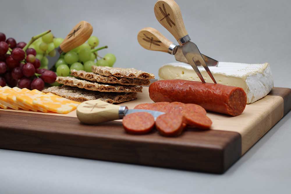 Walnut and maple charcuterie board with cutlery smoked sausage brie grapes colby jack and crackers charcuterie gift dragonfly wood arts