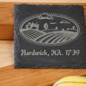 Customizable 4inch square slate coaster with a picture of a tractor plowing a field and the text hardwick ma 1739 dragonfly wood arts